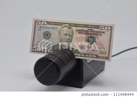 Banknotes and an electric knife sharpener. World financial crisis. The fight against inflation. Banknotes and an electric knife sharpener. World financial crisis. The fight against inflation. 111498444