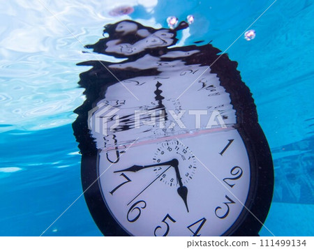 Alarm clock underwater in blue pool with distorted reflection 111499134