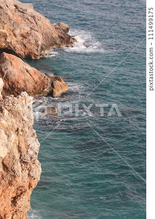 Storm at sea on Cleopatra Beach, foam waves against the background of the historic mountain 111499175