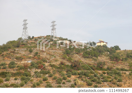 power line masts on the mountainside, the tower is installed on the top of the hill power line masts on the mountainside, the tower is installed on the top of the hill 111499267