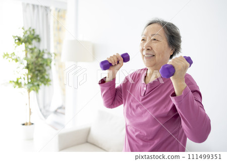 Asian senior woman doing exercises with dumbbells indoors. Asian senior woman doing exercises with dumbbells indoors. 111499351
