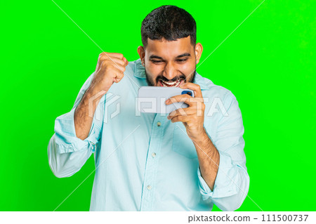 Happy man playing racing drive simulator, shooter video games on smartphone, celebrate victory win Happy man playing racing drive simulator, shooter video games on smartphone, celebrate victory win 111500737
