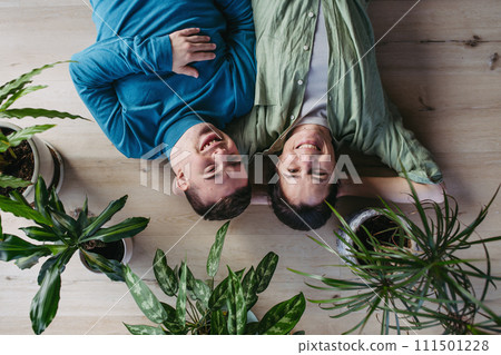 Portrait of young man with Down syndrome with his mother at home, lying on floor. Concept of love and parenting disabled child. Banner with copyspace. Portrait of young man with Down syndrome with his mother at home, lying on floor. Concept of love and parenting disabled child. Banner with copyspace. 111501228