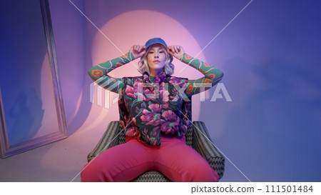 Cool hipster student woman wearing stylish outfit looking at camera and correcting her hat Cool hipster student woman wearing stylish outfit looking at camera and correcting her hat 111501484