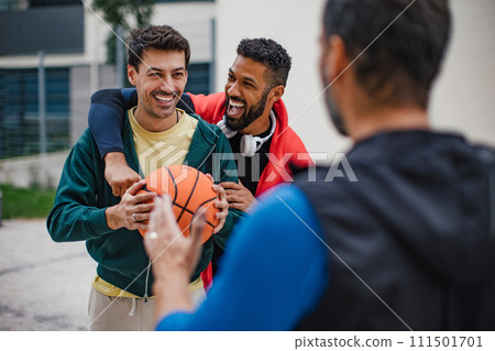 Best friends playing sport outdoors, having fun, competing. Playing basketball at a local court, enjoying exercise together. Concept of male friendship, bromance. Best friends playing sport outdoors, having fun, competing. Playing basketball at a local court, enjoying exercise together. Concept of male friendship, bromance. 111501701