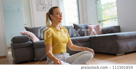 Woman exercising at home, stretching her body. Solo home workout and meditation, morning or evening workout routine. Banner with copy space. 111501859