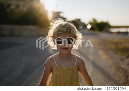 Portrait of blonde girl in summer outfit on walk during summer vacation, concept of beach holiday. 111501994