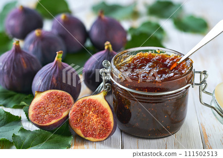 Orange jam with fresh figs slices on a white table. Figs marmalade for figs jam in glass jar. 111502513