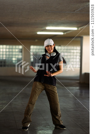 Full length of young woman practicing vigorous hip hop movements in parking garage 111503928
