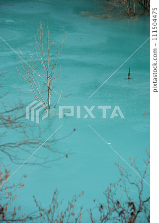 Turquoise waste waters from a copper mine polluting  the environment. Geamana decantation lake, Romania 111504475
