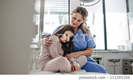 Supportive doctor soothing a worried children patient in emergency room. Hugging little girl before surgery. Hugging little girl before surgery. Concept of emotional support and friendliness for young 111505208