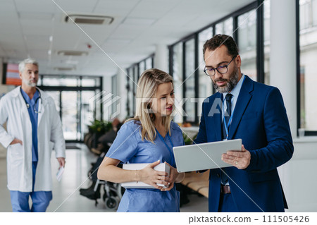 Pharmaceutical sales representative presenting new product to doctors in holding box with pills. Presenting new pharmaceutical product, drugs, medication. 111505426