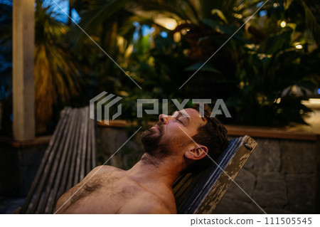 Handsome man lying on recliner, relaxing with closed eyes. Wellness weekend in spa for man. Handsome man lying on recliner, relaxing with closed eyes. Wellness weekend in spa for man. 111505545