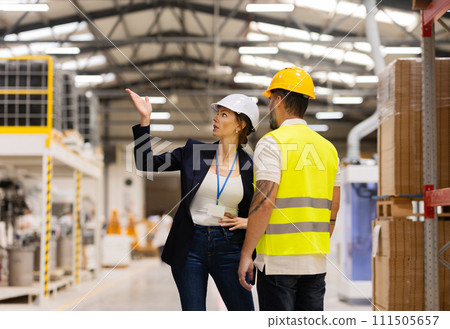 Female manager scolding employee in modern industry factory. Worker making mistake. Production manger is angry, dissatisfied for worker's poor quality work, safety viaolations. 111505657