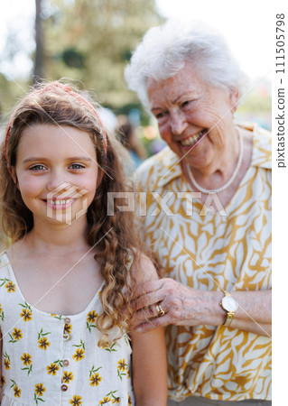 Portrait of girl with grandmother at garden party. Love and closeness between grandparent and grandchild. 111505798