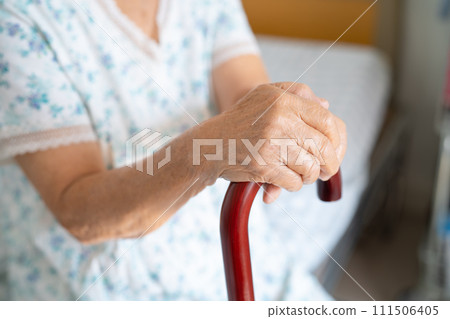 Asian elderly disability woman holding waling stick, wood cane, round handle, walking aid for help to walk. Asian elderly disability woman holding waling stick, wood cane, round handle, walking aid for help to walk. 111506405