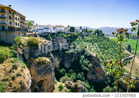Ronda town and valley, Andalusia, Spain. Popular landmark. Tourist attraction at sunset light, place to visit. View from the city on valley 111507068