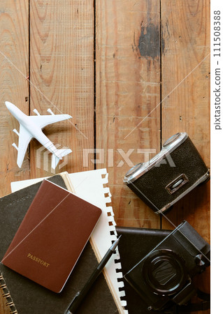 Travel concept with passport, camera, notebook and airplane on wooden background Travel concept with passport, camera, notebook and airplane on wooden background 111508388