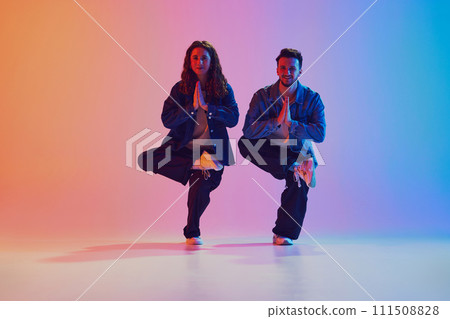 Dance duo, talented man and woman in dance poses against gradient studio background in neon light, filter. 111508828