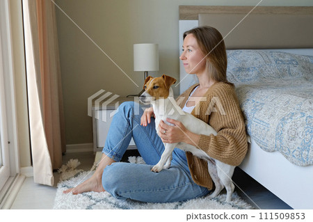 Woman with her jack russell pup at home. Woman with her jack russell pup at home. 111509853