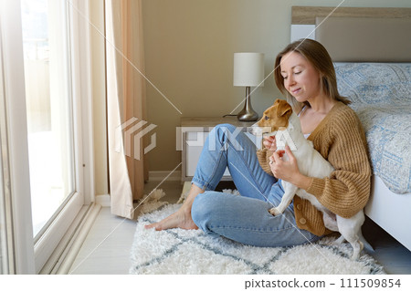 Woman with her jack russell pup at home. 111509854