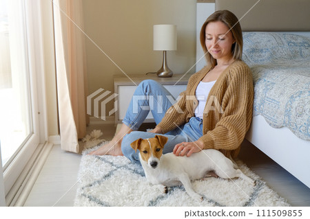 Woman with her jack russell pup at home. Woman with her jack russell pup at home. 111509855
