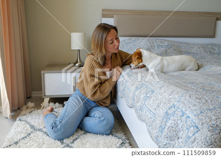 Woman with her jack russell pup at home. 111509859