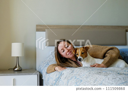 Woman with her jack russell pup at home. Woman with her jack russell pup at home. 111509868