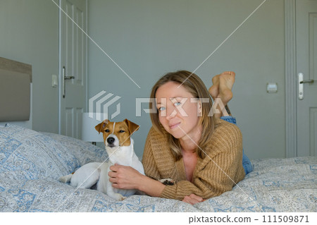 Woman with her jack russell pup at home. 111509871
