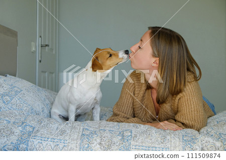 Young woman kissing her dog Young woman kissing her dog 111509874