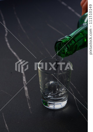 Pour Korean soju into a glass 111510149