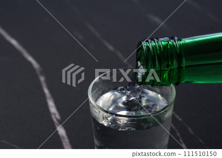 Pour Korean soju into a glass 111510150