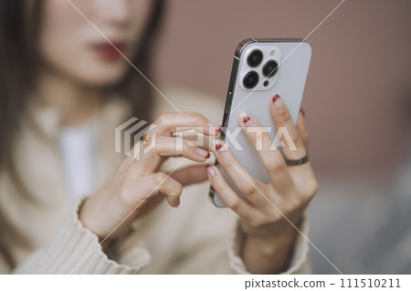 操作智能手機的年輕女子的手 111510211