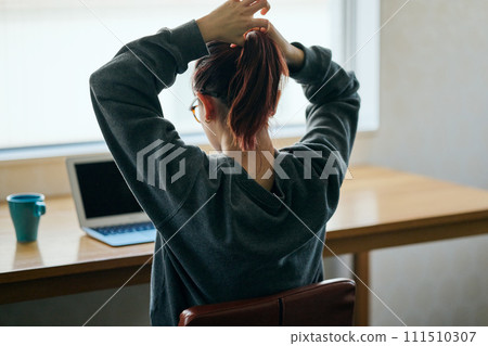 young woman tying her hair back 111510307