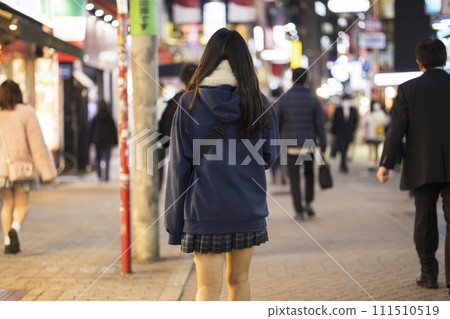 夜間穿過澀谷中心街的身穿制服的女高中生的後視圖 夜間穿過澀谷中心街的身穿制服的女高中生的後視圖 111510519