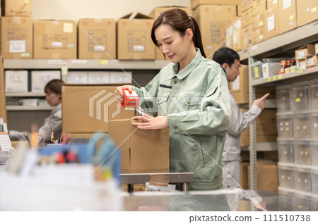 穿著工作服的女人正在做包裝工作 穿著工作服的女人正在做包裝工作 111510738
