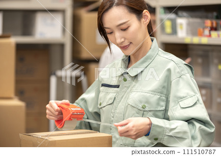 A woman in work clothes doing packing work 111510787
