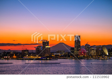 Japan's Yokohama cityscape Minato Mirai and Mt. Fuji reflected in the sunset. Yokohama Customs and Prefectural Police on the left, towards Sakuragicho Station in the back 111510902