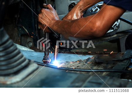 Close up of welding auto body with gas torch at auto repair shop Close up of welding auto body with gas torch at auto repair shop 111511088