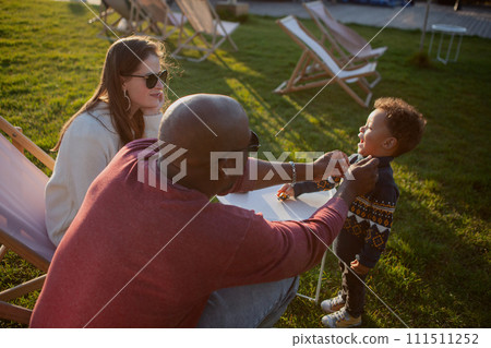 Multiethnic family with child having fun in nature park. African American dad plays with his son at sunset. Authentic moment, lifestyle Multiethnic family with child having fun in nature park. African American dad plays with his son at sunset. Authentic moment, lifestyle 111511252
