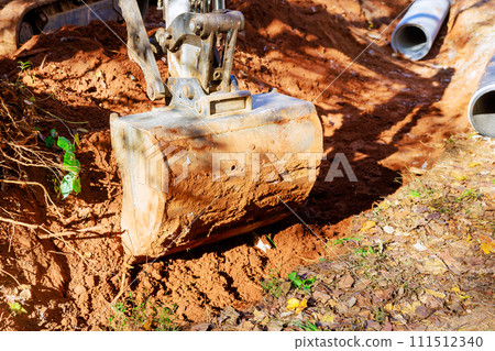 Excavator digs trench through which rainwater will flow to collector 111512340