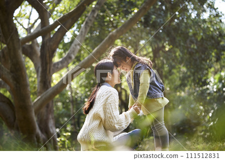 asian mother and daughter having a good time outdoors in park 111512831
