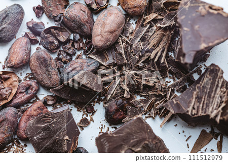 Cocoa beans with chocolate on a white background. Shalllow dof. Cocoa beans with chocolate on a white background. Shalllow dof. 111512979