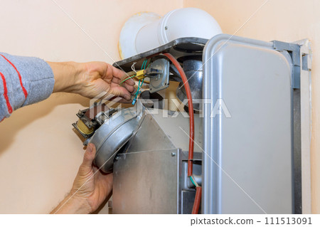 Professional qualified engineer servicing natural gas boiler at home is engaged in gas boiler repair 111513091
