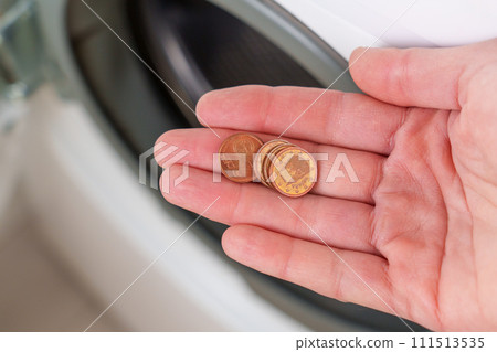 Coins found from the drum of a washing machine, left in clothing pockets close up in hand Coins found from the drum of a washing machine, left in clothing pockets close up in hand 111513535