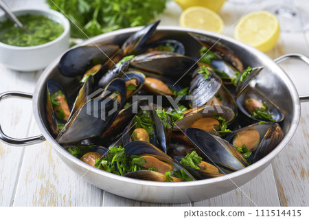 Clams mussels in a stainless steel bowl with lemon and herbs. Shellfish seafood. 111514415