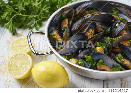 Mussels with french fries and herbs in cooking pan. White background. Close up. Mussels with french fries and herbs in cooking pan. White background. Close up. 111514417