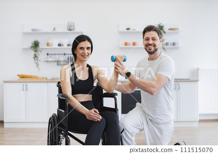 Handicapped mature woman training with dumbbells. 111515070