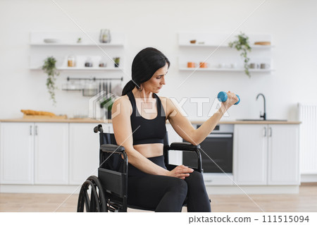 Caucasian female working out with dumbbell while staying in good mood. 111515094