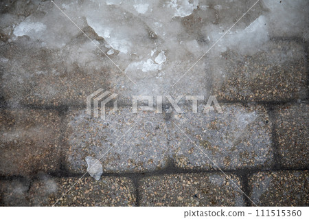 Close-up of ice on pavement, slippery sidewalks in winter 111515360